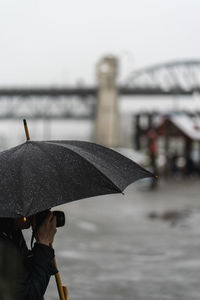 Person holding wet umbrella during rainy season