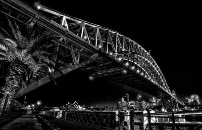 Illuminated bridge over river at night