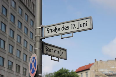 Low angle view of sign board against blue sky