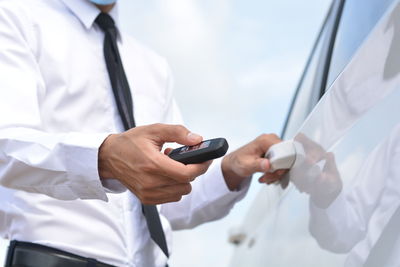 Midsection of man using mobile phone