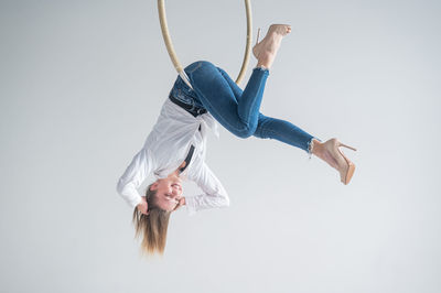 Low section of woman with arms raised against white background