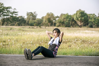 Full length portrait of woman sitting on field