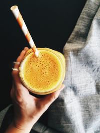 Close-up of hand holding coffee cup on table