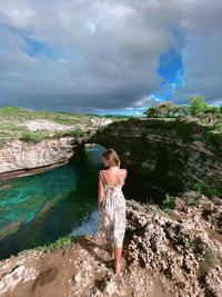 Rear view of woman standing by lake