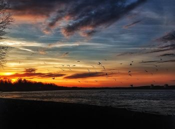 Scenic view of sea against dramatic sky during sunset