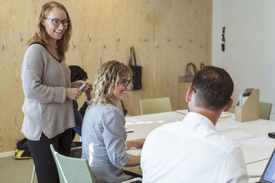 Smiling business professionals discussing in board room at office