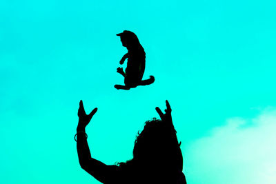 Low angle view of silhouette man against blue sky