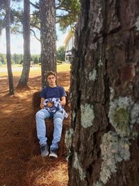 Girl standing on tree trunk