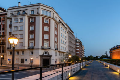 Street amidst buildings against sky at dusk