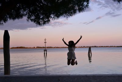 Man standing on beach against sky during sunset