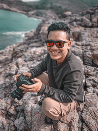 Portrait of smiling young man on rock