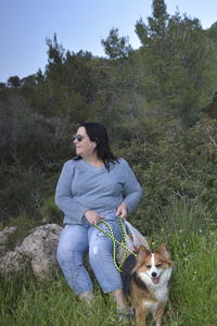 Full length of woman with dog on field