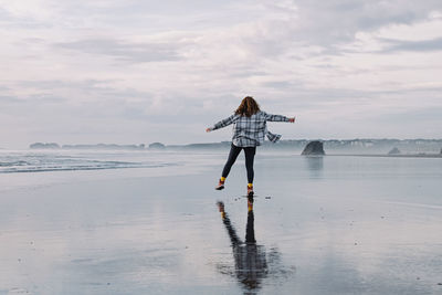 Full length of man standing on beach against sky