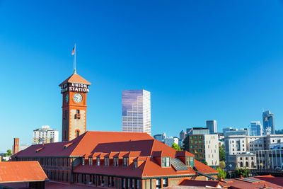 Low angle view of buildings against clear blue sky