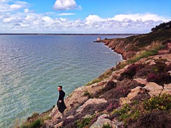 Rear view of woman standing by sea