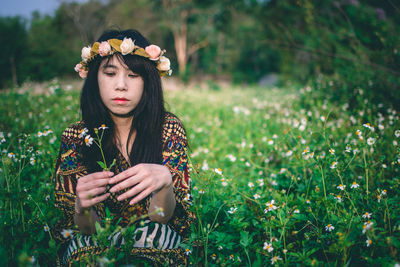 Young woman with flower petals on field