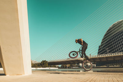 Man riding bmx cycle on footpath in city