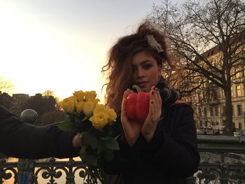 Portrait of young woman with heart shape against sky