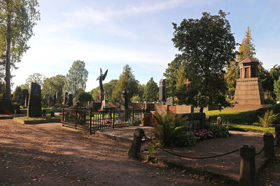 Trees in cemetery against sky