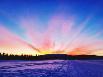 Scenic view of frozen lake against sky during sunset