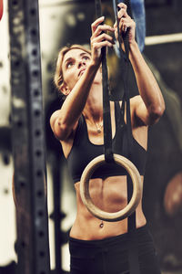 Young woman preparing gymnastic rings