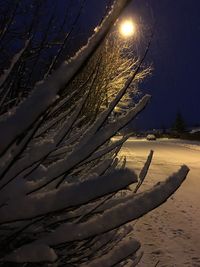 Snow covered land against sky at night