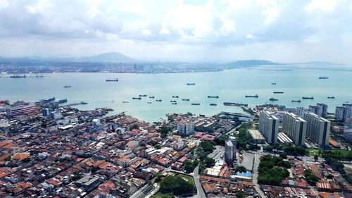 High angle view of cityscape by sea against sky