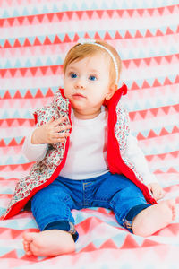 Portrait of cute girl sitting on bed