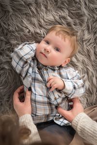 Portrait of cute baby boy lying on carpet