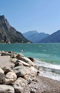 Scenic view of sea and mountains against clear sky