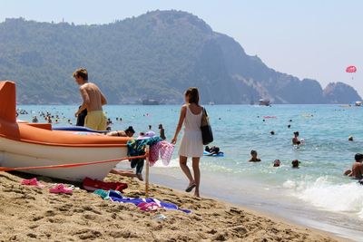 People at beach against clear sky