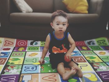 Portrait of cute baby boy sitting at home