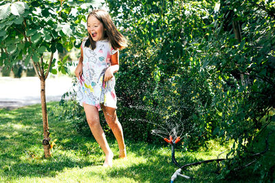 Full length of girl standing against plants