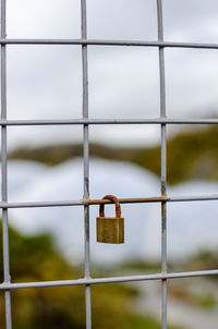 Close-up of padlocks on padlock against sky