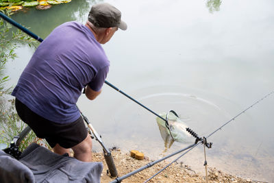 Successful bream fishing. happy fisherman with big walleye fish trophy at lake