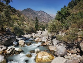 Scenic view of river amidst mountains against clear sky