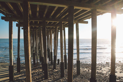 Silhouette pier over sea against sky