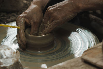 Cropped hands of man making pot