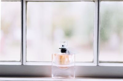 Close-up of water bottle on window sill