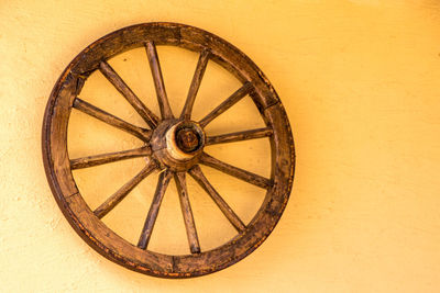 Close-up of old wheel against wall