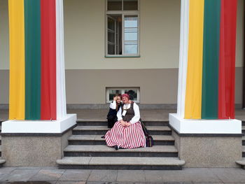 Mother and son sitting on steps in city