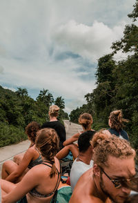 Rear view of people at park against sky