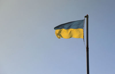 Low angle view of flag against clear sky