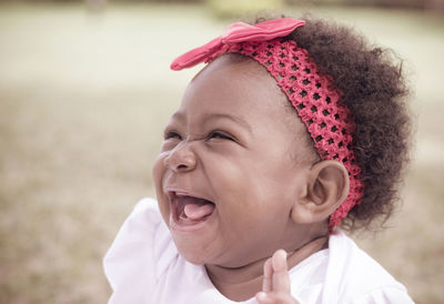 Close-up of happy toddler girl wearing red headband