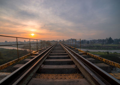 Empty railroad tracks during sunset