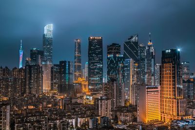 Illuminated buildings in city against sky at night