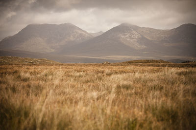 Scenic view of land and mountains against sky