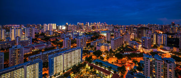 High angle view of illuminated buildings against sky at night