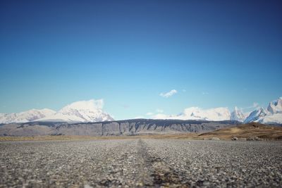 Scenic view of snowcapped mountains against blue sky