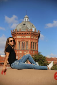 Full length of woman sitting against sky